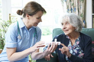 a nurse assist the elderly woman's medication